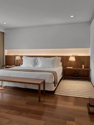 Geräumiges Hotelzimmer mit Kingsize-Bett und Holzinterieur