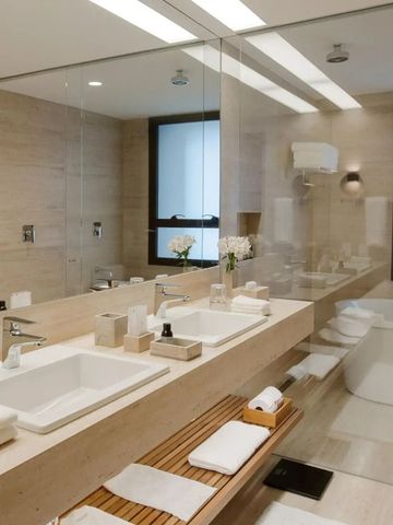 Geräumiges Badezimmer mit zwei Waschbecken, großen Spiegeln und moderner Einrichtung.