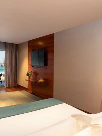 Suite mit Meerblick und Terrasse. Fernseher und Sitzgelegenheit im Raum.