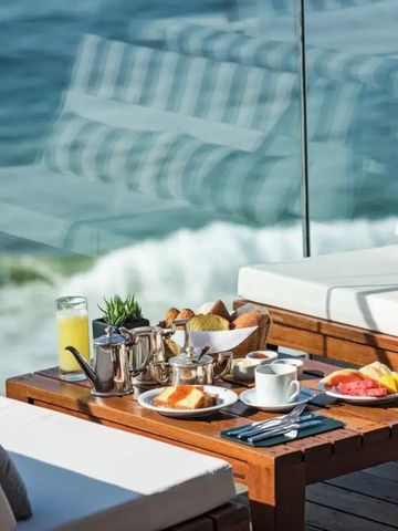 Terrassenecke mit Frühstück auf einem Tisch am Ozean