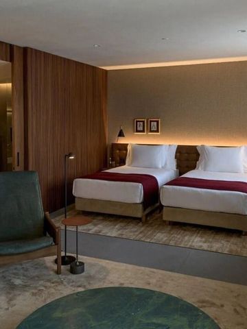 Luxuriöses Hotelzimmer mit zwei Betten, moderner Dekor und Holzdetails