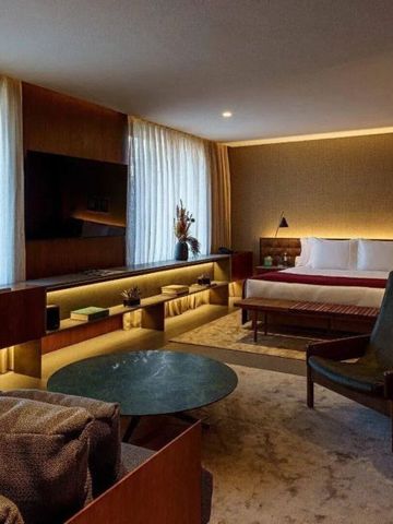 Geräumige Hotelsuite mit großem Bett, Sitzbereich und stilvollem Dekor