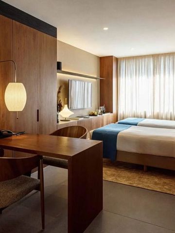 Einladendes Hotelzimmer mit Schreibtisch, warmem Licht und eleganten Möbeln