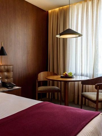 Einladender Sitzbereich mit Tisch und zwei Stühlen in einem Zimmer mit großem Fenster