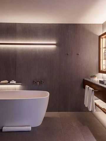 Modernes Badezimmer mit freistehender Badewanne und eleganter Beleuchtung