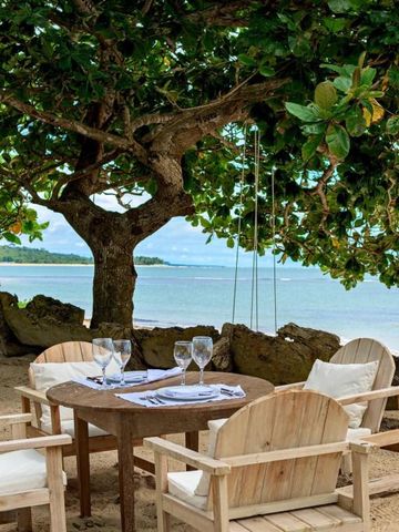 Gemütliche Sitzgruppe unter einem schattigen Baum am Strand