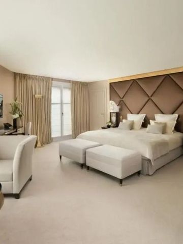 Geräumiges Hotelzimmer mit neutralen Tönen, einladendem Bett und Sitzbereich