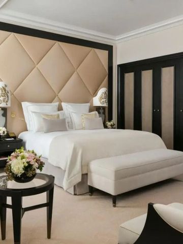 Helles Hotelzimmer in eleganten Farben mit luxuriösen Möbeln und Blumenarrangement