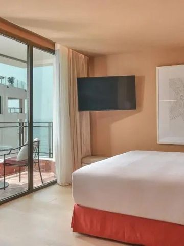 Helles Hotelzimmer mit Zugang zum Balkon und Meerblick