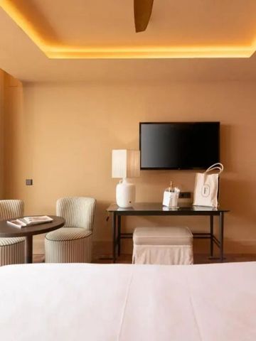 Modernes Hotelzimmer im El Fuerte Marbella mit Fernseher und gemütlicher Sitzecke