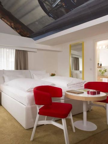 Helles Schlafzimmer mit roten Stühlen und Dachschräge