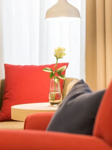 Gemütliche Sitzecke mit roter Dekoration und Blume