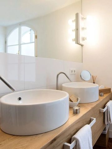 Zwei moderne Waschbecken auf Holzunterlage im hellen Badezimmer