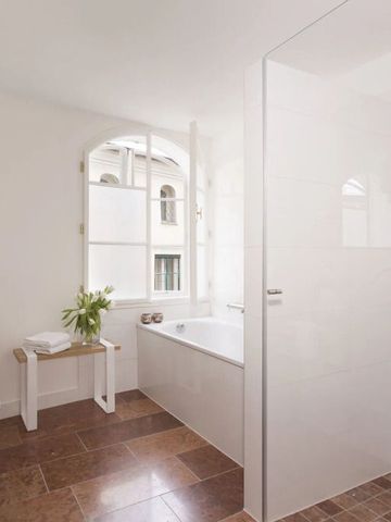 Lichtdurchflutetes Badezimmer mit Badewanne und moderner Einrichtung