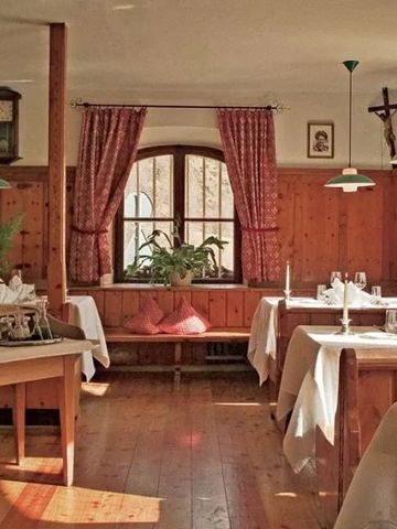 Gemütliches Restaurant mit Holzmöbeln und roten Vorhängen