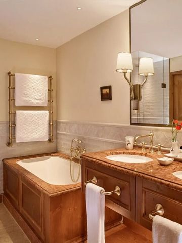 Badezimmer mit klassischer Badewanne und zwei Waschbecken