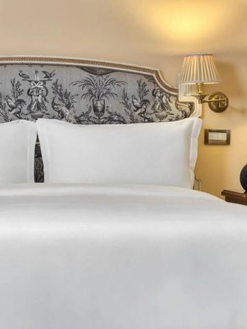 Geschmackvoll eingerichtetes Hotelzimmer mit Doppelbett und Designerleuchten