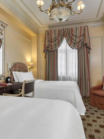 Klassisches Zweibettzimmer mit stilvoller Einrichtung und prächtigem Kronleuchter