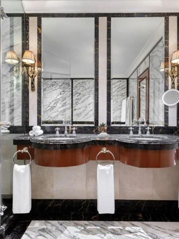 Marmorbadezimmer mit Doppelwaschbecken und eleganter Beleuchtung.