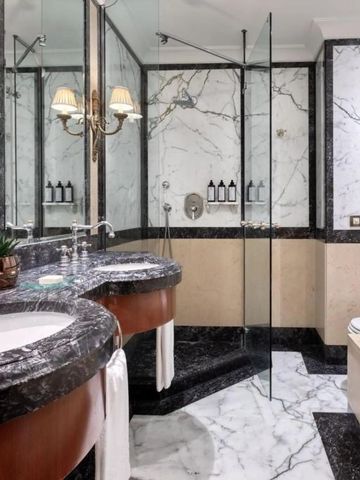 Luxuriöses Badezimmer mit Marmorfliesen und Doppelwaschbecken