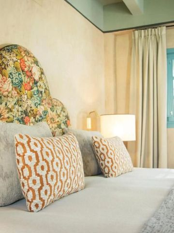 Elegantes Hotelzimmer mit floralem Kopfteil und stilvollen Kissen