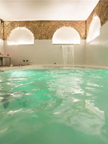 Eleganter Spa-Bereich mit beleuchtetem Innenpool und gemauerten Rundbögen