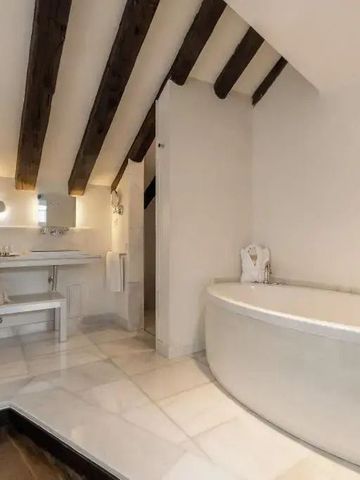 Elegantes Badezimmer mit Holzdecke und freistehender Badewanne