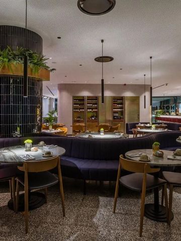 Elegantes Hotelrestaurant mit gedeckten Tischen und Pflanzen