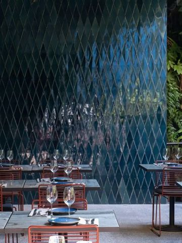 Terrassenrestaurant mit modernen Stühlen und Pflanzenwand