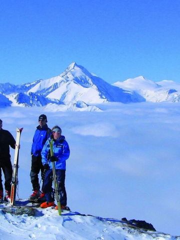 Skifahrer posieren vor einer beeindruckenden Panoramalandschaft
