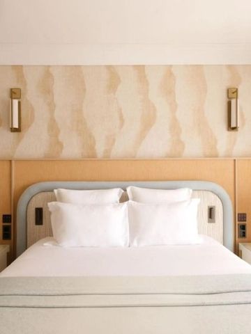 Helles Hotelzimmer mit Doppelbett und luxuriösem Design.