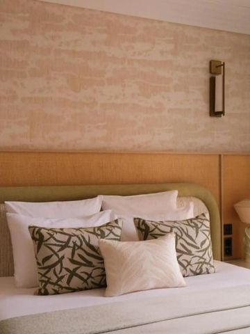 Stilvolles Schlafzimmer mit modernen Kissen und Kunst an der Wand.