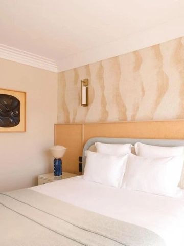 Elegant eingerichtetes Schlafzimmer mit Doppelbett und zeitgenössischem Kunstwerk an der Wand