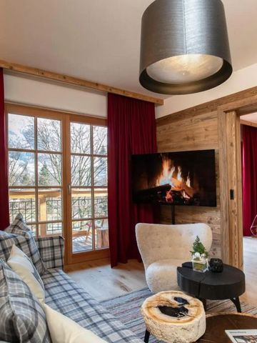 Wohnbereich einer Suite mit Kamin und Ausblick auf Berge