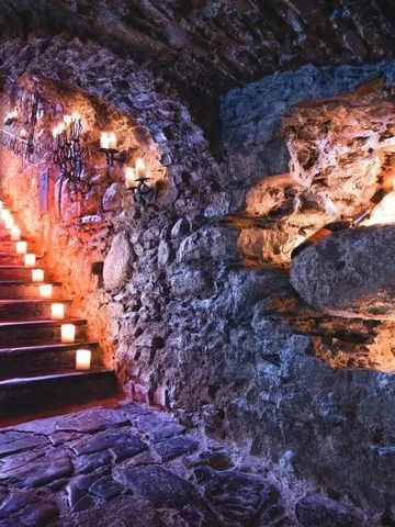 Historischer Gewölbekeller mit Kerzenbeleuchtung und Steintreppen