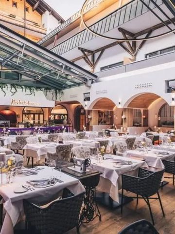 Elegantes Restaurant mit moderner Glasdecke und gedeckten Tischen