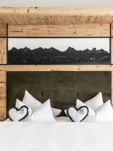 Elegantes Hotelzimmer mit rustikaler Holzwand und Bergbild