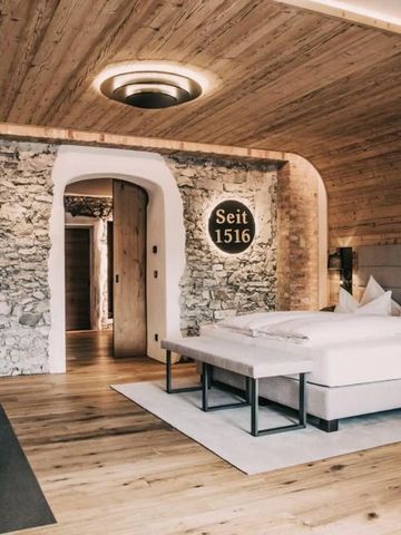 Geräumiges Hotelzimmer mit Steinwand und Holzelementen