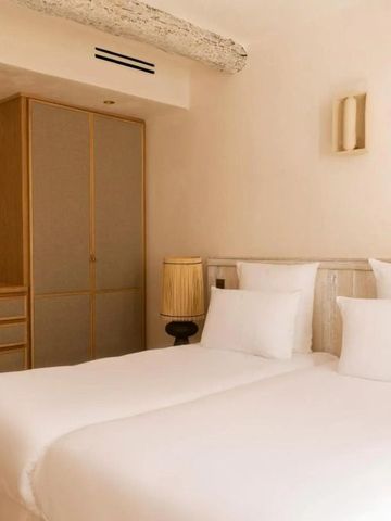 Doppelbett in einem stilvoll eingerichteten Hotelzimmer mit Holzbalken.