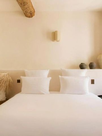 Großes Bett mit dekorativen Kissen in einem hellen, eleganten Zimmer.