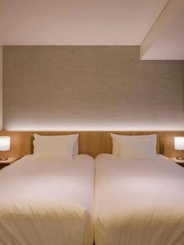 Komfortables Hotelzimmer mit zwei Einzelbetten und dezenter Beleuchtung