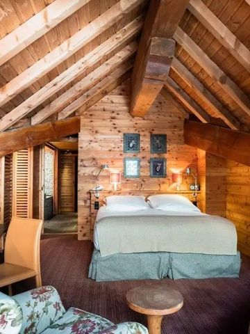 Gemütliches Zimmer mit holzverkleideten Wänden und Dachschräge