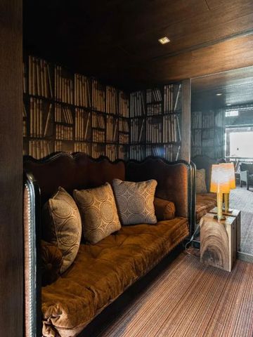 Gemütliche kleine Lounge mit Bücherregaltapete im Hotel Le Blizzard