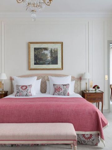 Geräumiges Schlafzimmer mit rotem Überwurf und Kronleuchter