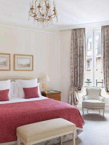 Helles Schlafzimmer mit rotem Bettüberwurf und klassischem Mobiliar