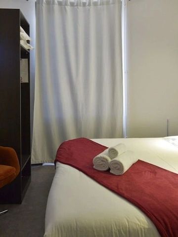 Elegantes Hotelzimmer mit Bett und roten Akzenten