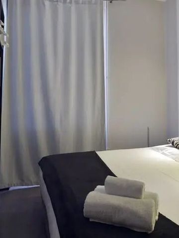 Modern eingerichtetes Zimmer mit Doppelbett und schwarzen Details