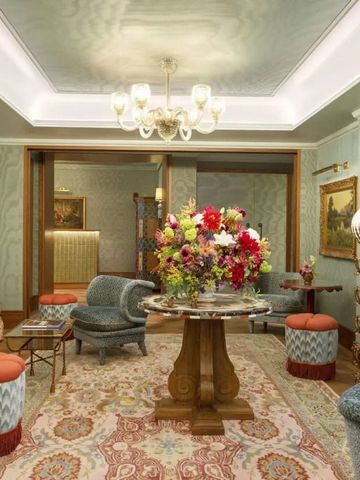 Prächtig eingerichtete Lounge mit Blumen und eleganten Sitzmöbeln