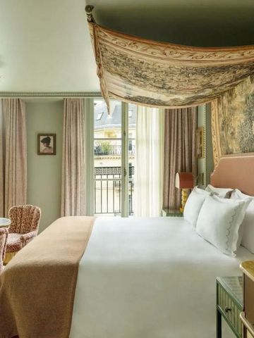 Elegantes Hotelzimmer mit Baldachin und Fenster zur Stadt