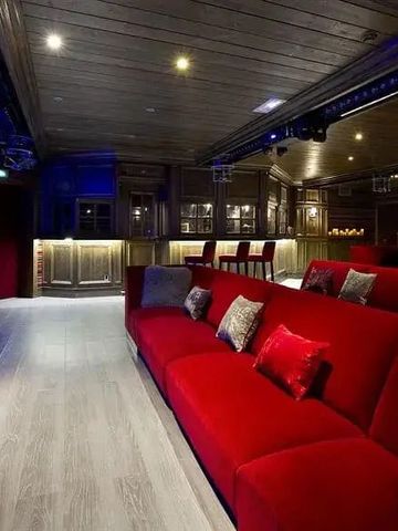 Moderner Kinosaal mit roten Samtsofas und angenehmer Beleuchtung